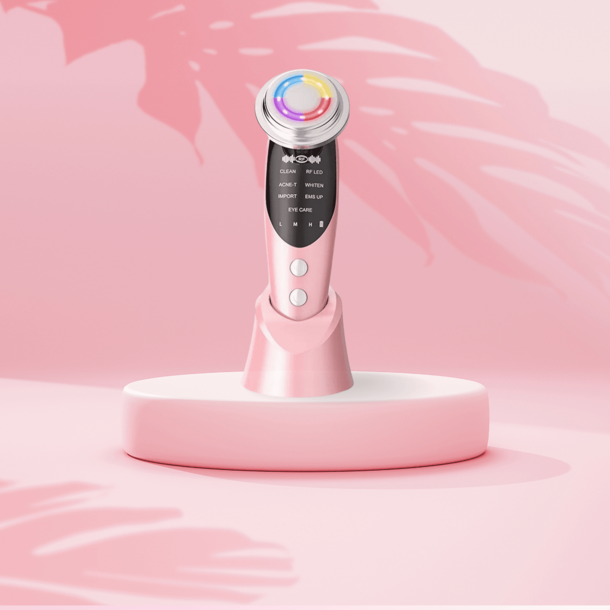 Tri-light LED therapy facial device on pink podium with the background showing shadow of palm trees